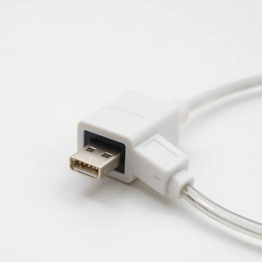 מחבר USB תקוע היטב במתאם חשמל עם כבל ברור בתאורה נקייה ומינימלית
